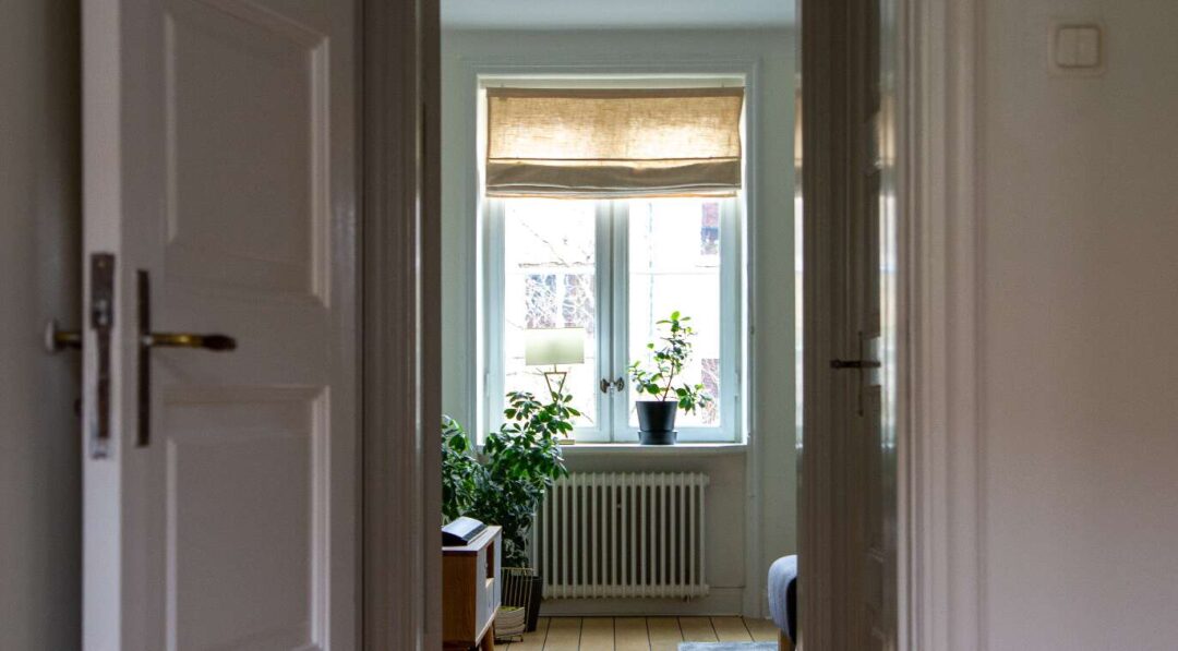 Fönster med hissgardin i lägenhet med vita väggar